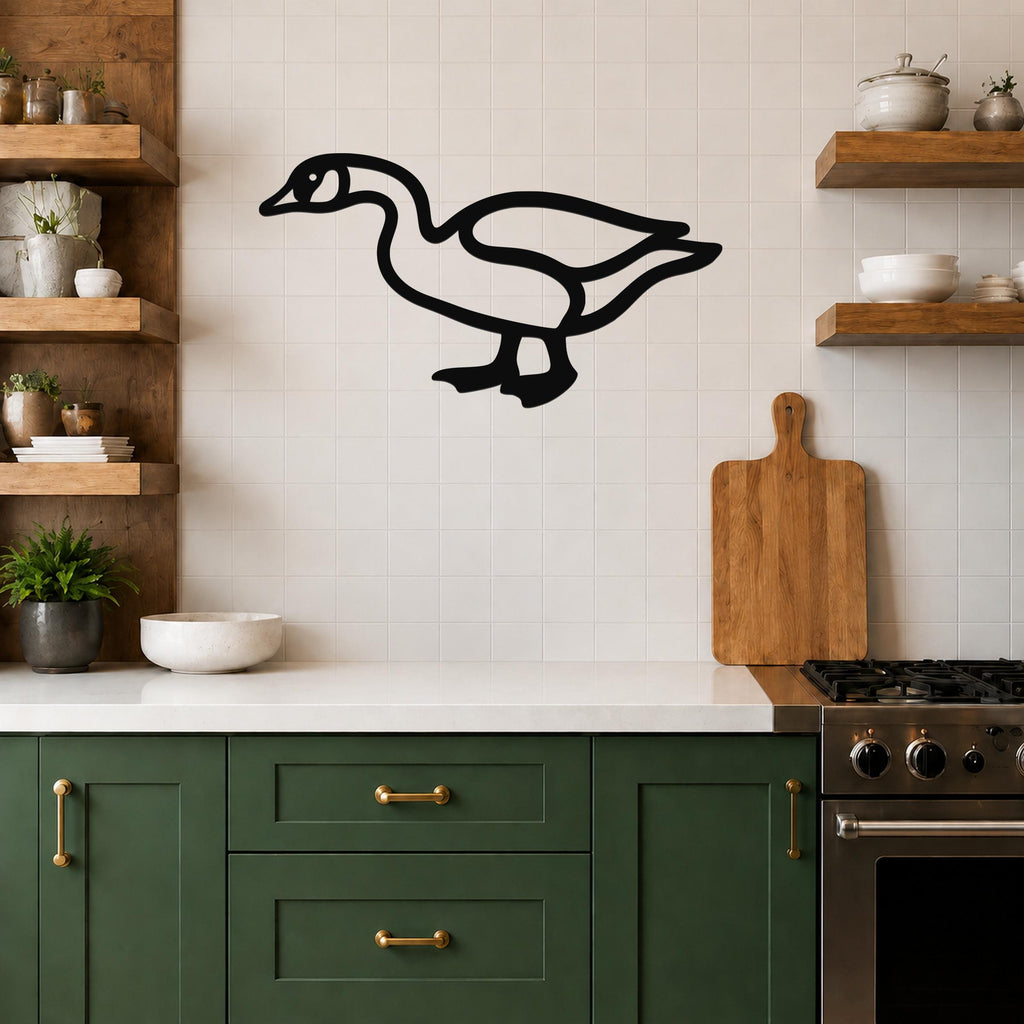 Black metal goose wall art silhouette mounted on a tiled kitchen wall above a counter, with wooden shelves and green cabinets visible.