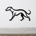 Black metal greyhound wall art with a sleek silhouette, mounted on a white wall above a light wood surface.