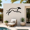 Black metal greyhound wall art with motion-line cutouts, mounted on an outdoor patio wall above a lounge chair near a pool.