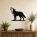 Black metal coyote howling wall art silhouette mounted above a wooden console table in a living room, flanked by two potted plants.