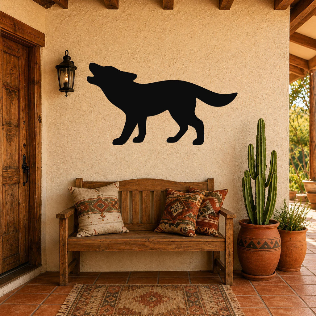 Black metal coyote wall art in a howling silhouette, mounted on a stucco wall above a wooden bench in a rustic patio entryway.