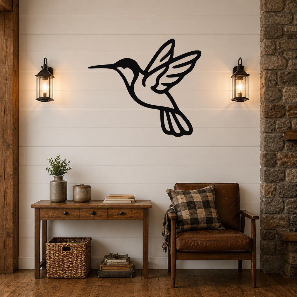 Black metal hummingbird wall art with motion-line cutouts, mounted on a white shiplap wall above a wooden console table in a living room.