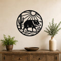 Black metal circular wall art featuring a javelina silhouette, cactus, and sun rays, mounted above a wooden console table in a living room.