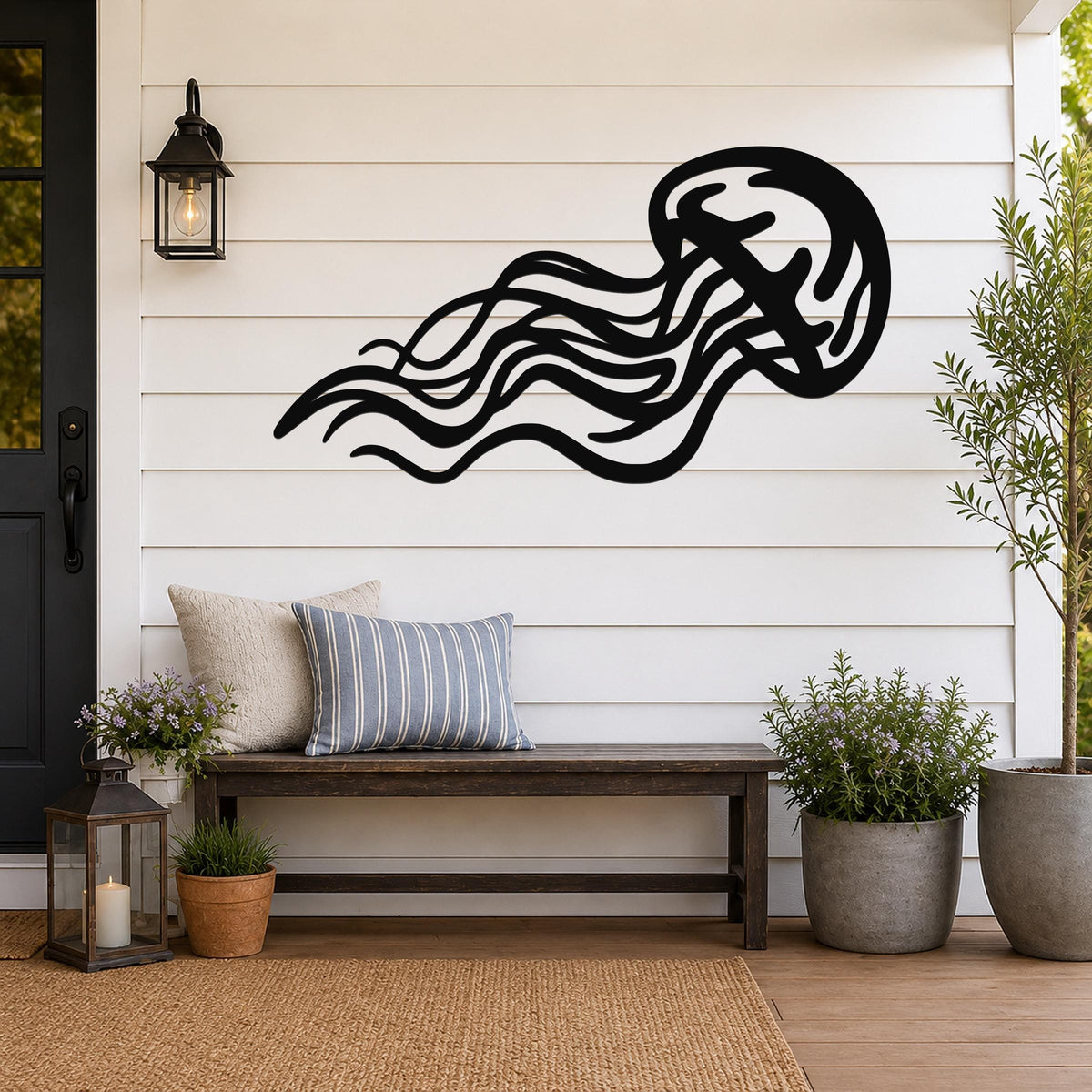 Black metal jellyfish wall art with flowing tentacle cutouts, mounted on a white shiplap wall above a wooden bench on a porch.