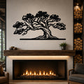 Black metal juniper tree wall art with intricate branch cutouts, mounted above a fireplace in a living room.