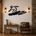 Black metal wall art silhouette of a snowboarder in motion, mounted on a shiplap wall above a wooden console table in a living room.