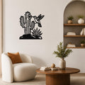 Black metal wall art featuring a cactus, flower, and hummingbird cutout, mounted on a living room wall above a white armchair.