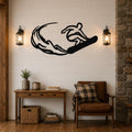 Black metal wall art silhouette of a snowboarder in motion, mounted above a wooden console table in a living room with shiplap walls and lanterns.