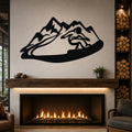 Black metal wall art with a snowboarder silhouette cutting through a mountain range, mounted above a fireplace in a living room.