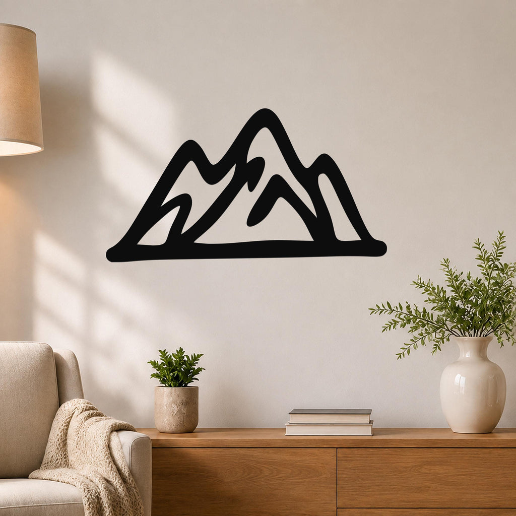 Black metal mountain silhouette wall art with layered peaks, mounted on a living room wall above a wooden console table.