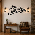 Black metal wall art featuring a snowboarder silhouette in dynamic motion above a mountain range, mounted on a shiplap wall above a wooden console table in a living room.