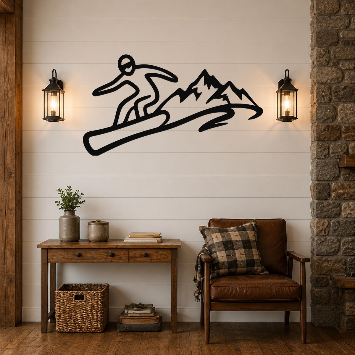 Black metal wall art featuring a snowboarder silhouette in dynamic motion above a mountain range, mounted on a shiplap wall above a wooden console table in a living room.