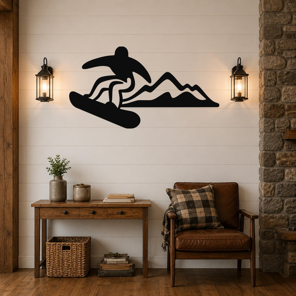 Black metal wall art featuring a snowboarder silhouette in dynamic motion above mountain peaks, mounted on a shiplap wall between two lanterns in a living room.