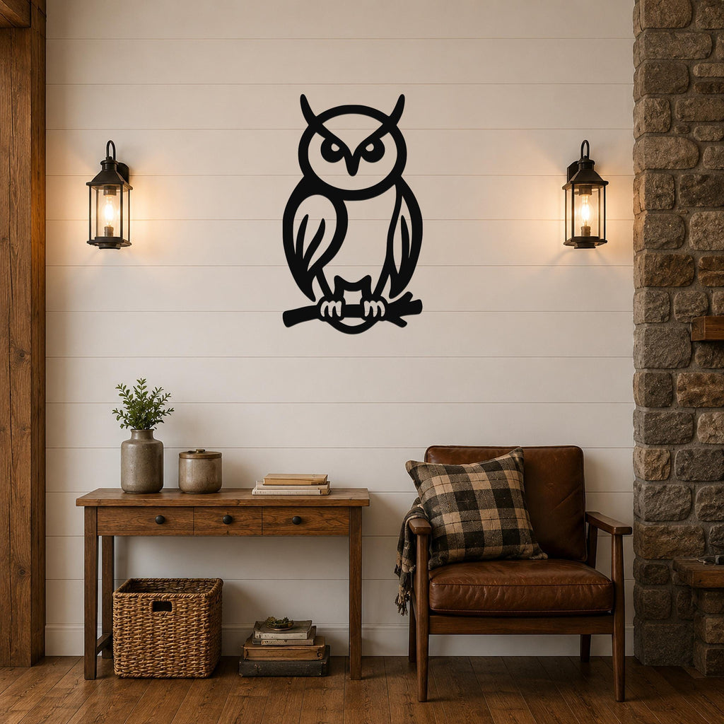 Black metal owl wall art in a silhouette style, perched on a branch, mounted on a shiplap wall above a wooden console table in a living room.