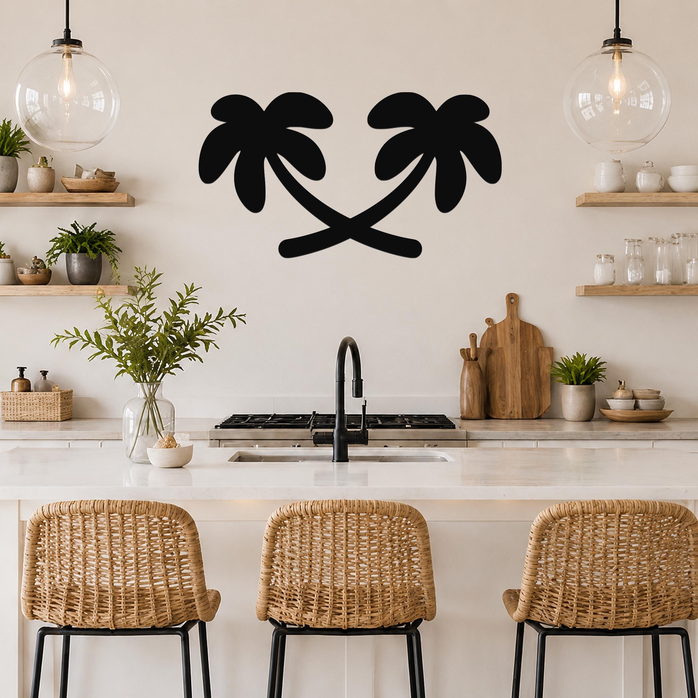 Black metal palm tree wall art with two silhouetted trees, mounted on a kitchen wall above a counter.