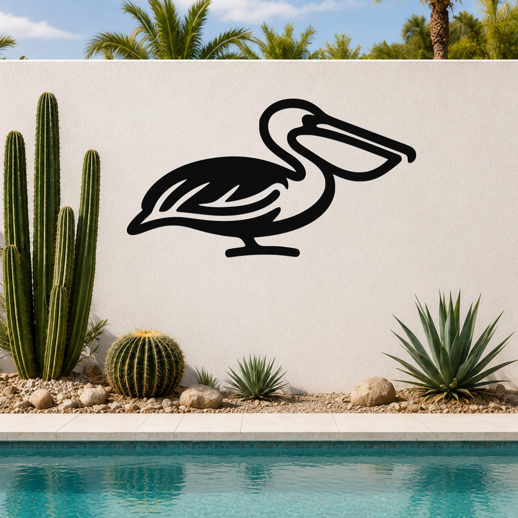 Black metal pelican wall art with a silhouette cutout design, mounted on a white outdoor wall beside a pool and desert plants.