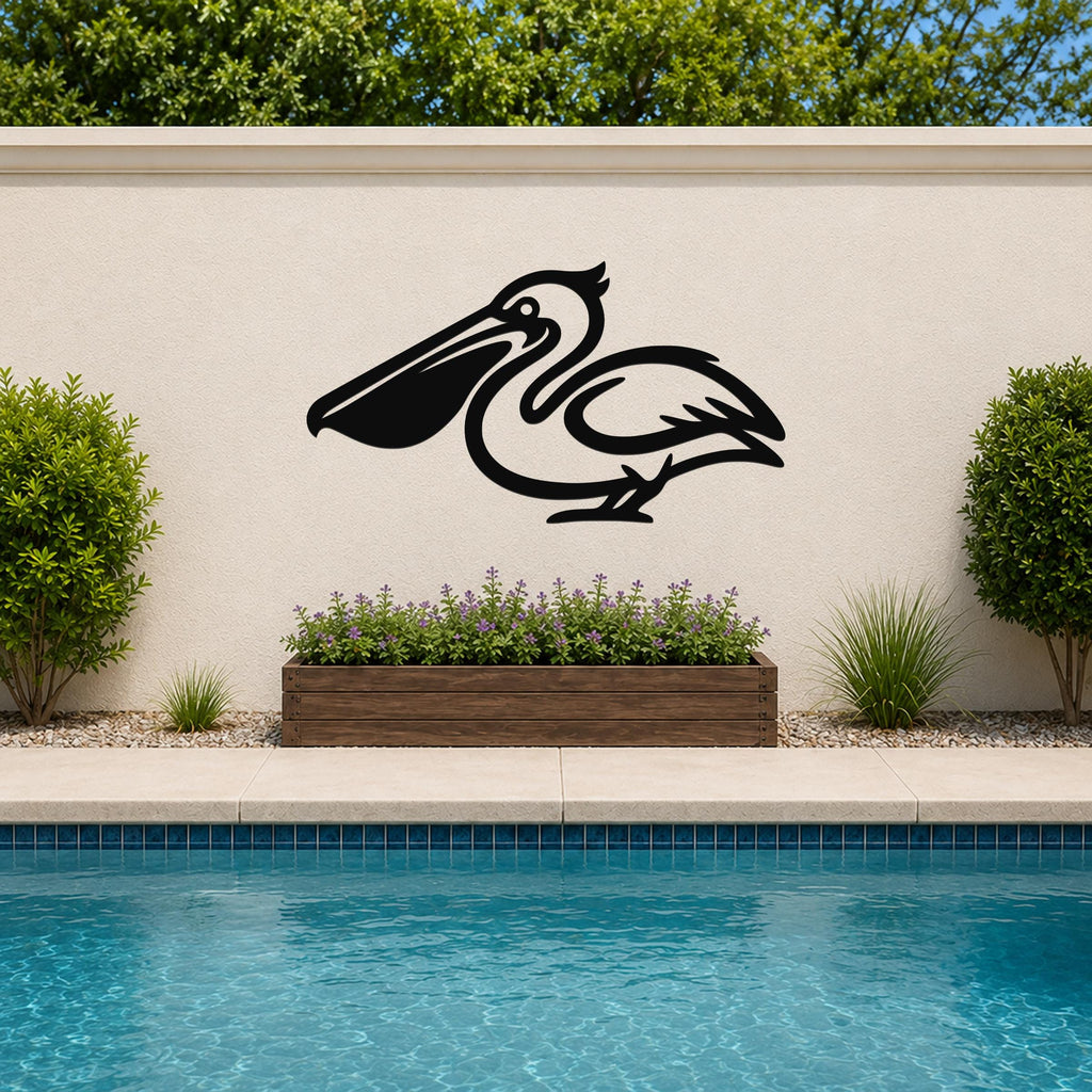Black metal pelican wall art silhouette mounted on an outdoor wall above a poolside planter with purple flowers.