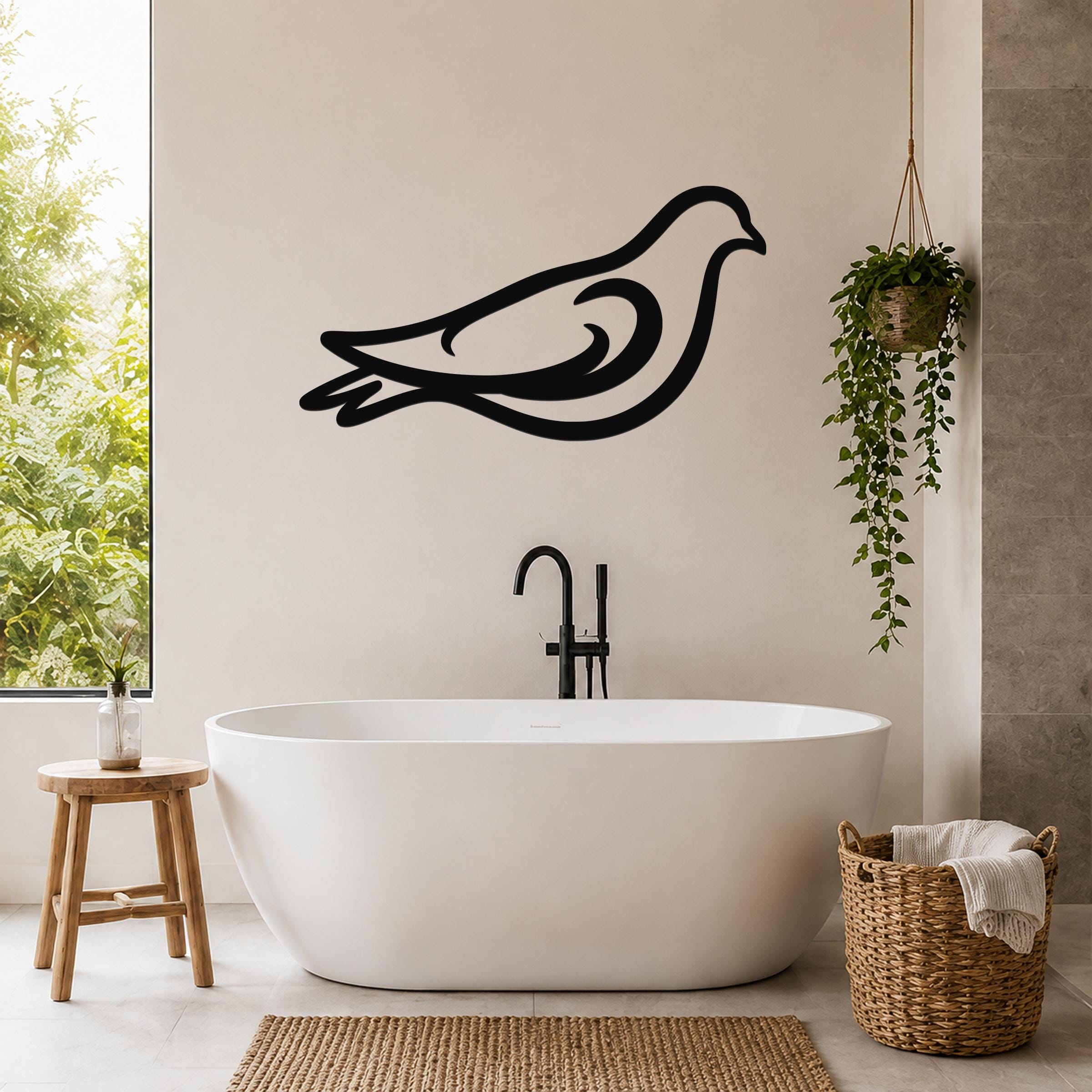 Black metal pigeon wall art with flowing silhouette lines, mounted on a bathroom wall above a freestanding tub.