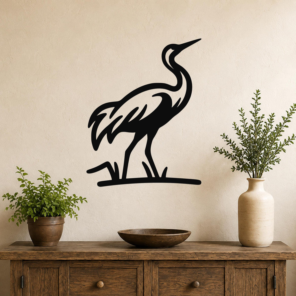 Black metal crane wall art in a minimalist silhouette style, mounted on a beige wall above a wooden console table with potted plants.