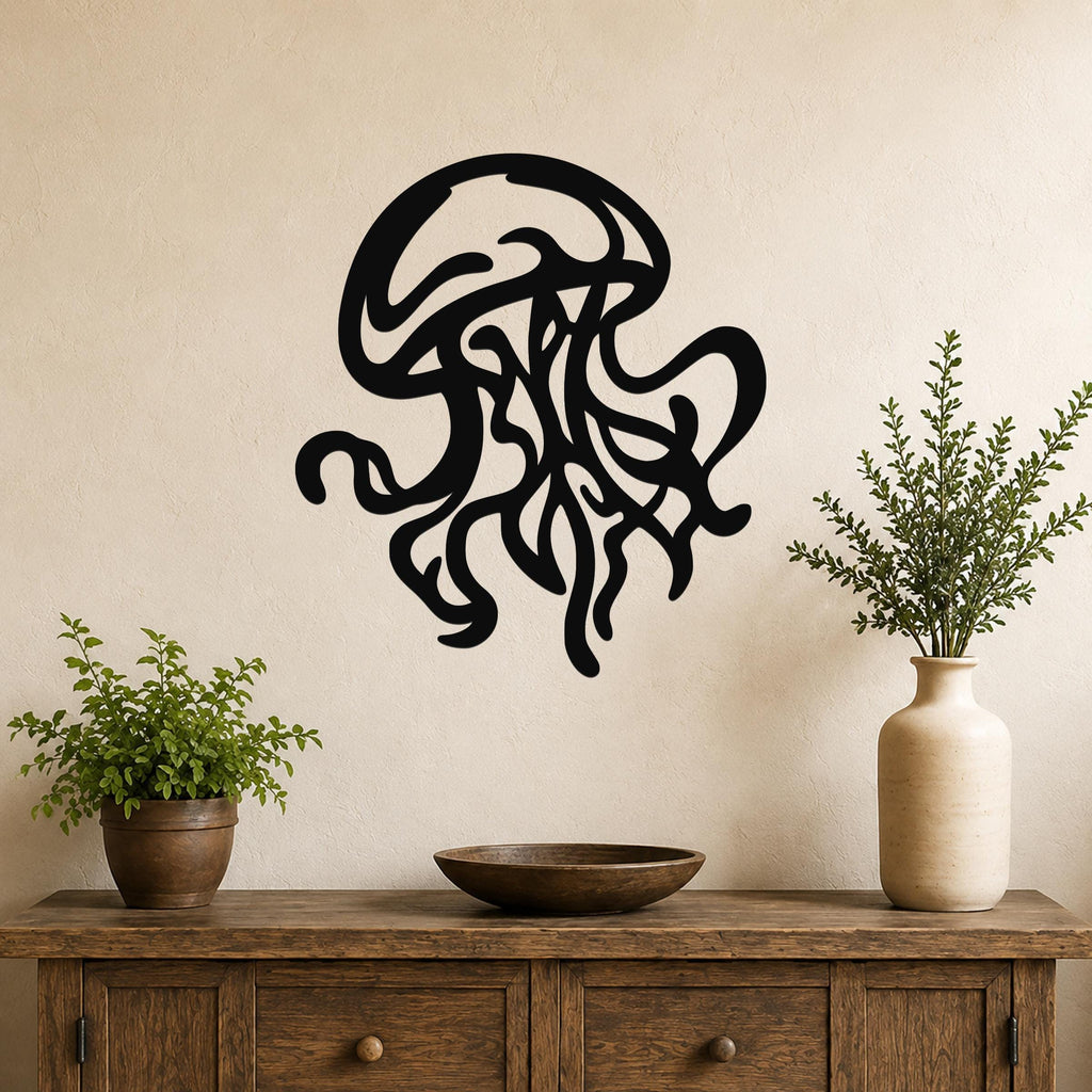 Black metal jellyfish wall art with flowing tentacle cutouts, mounted on a beige wall above a wooden console table with plants.