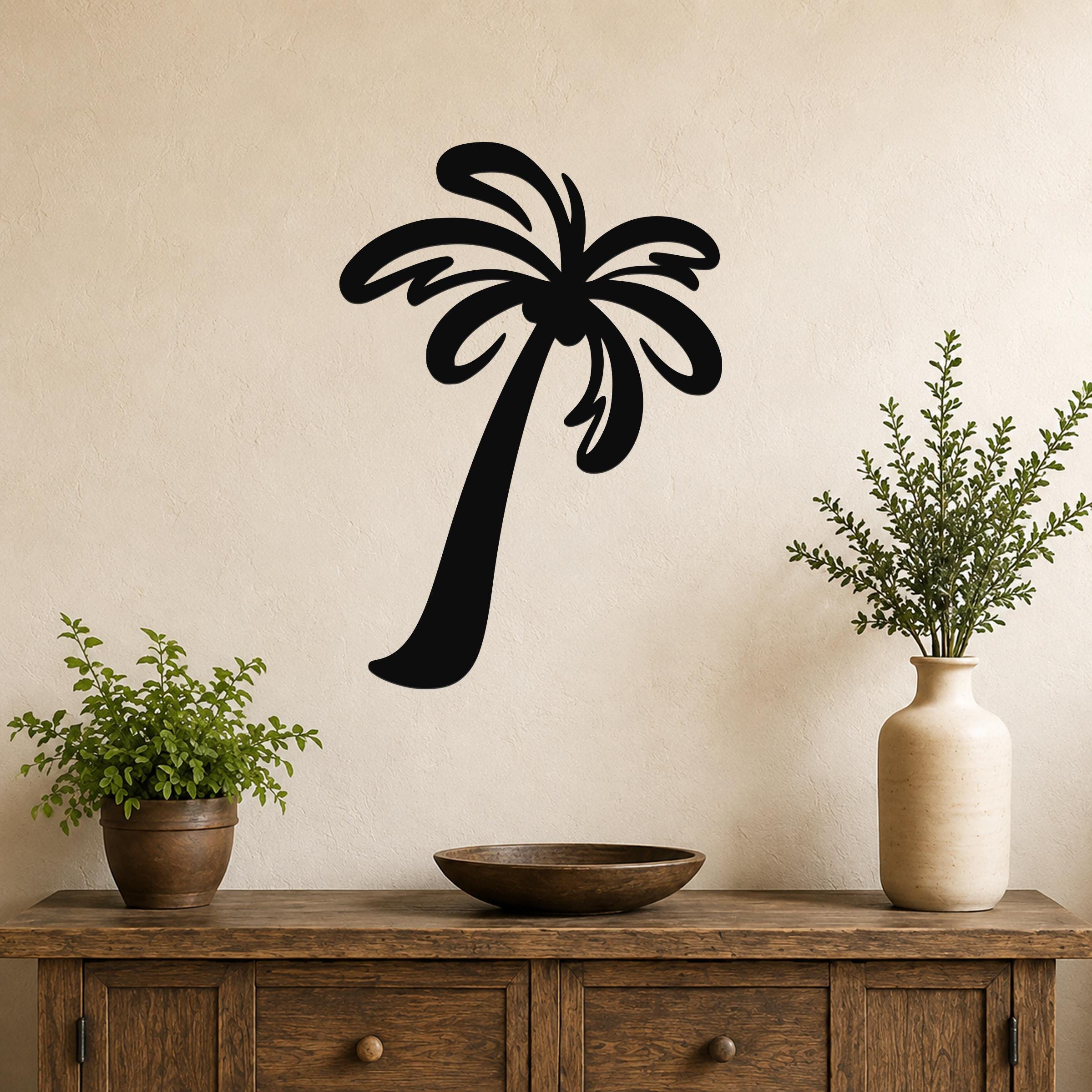 Black metal palm tree wall art with flowing frond cutouts, mounted on a beige wall above a wooden console table with potted plants.