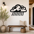 Black metal rain cloud wall art with raindrop cutouts, mounted on a white wall above a wooden bench in a modern entryway.