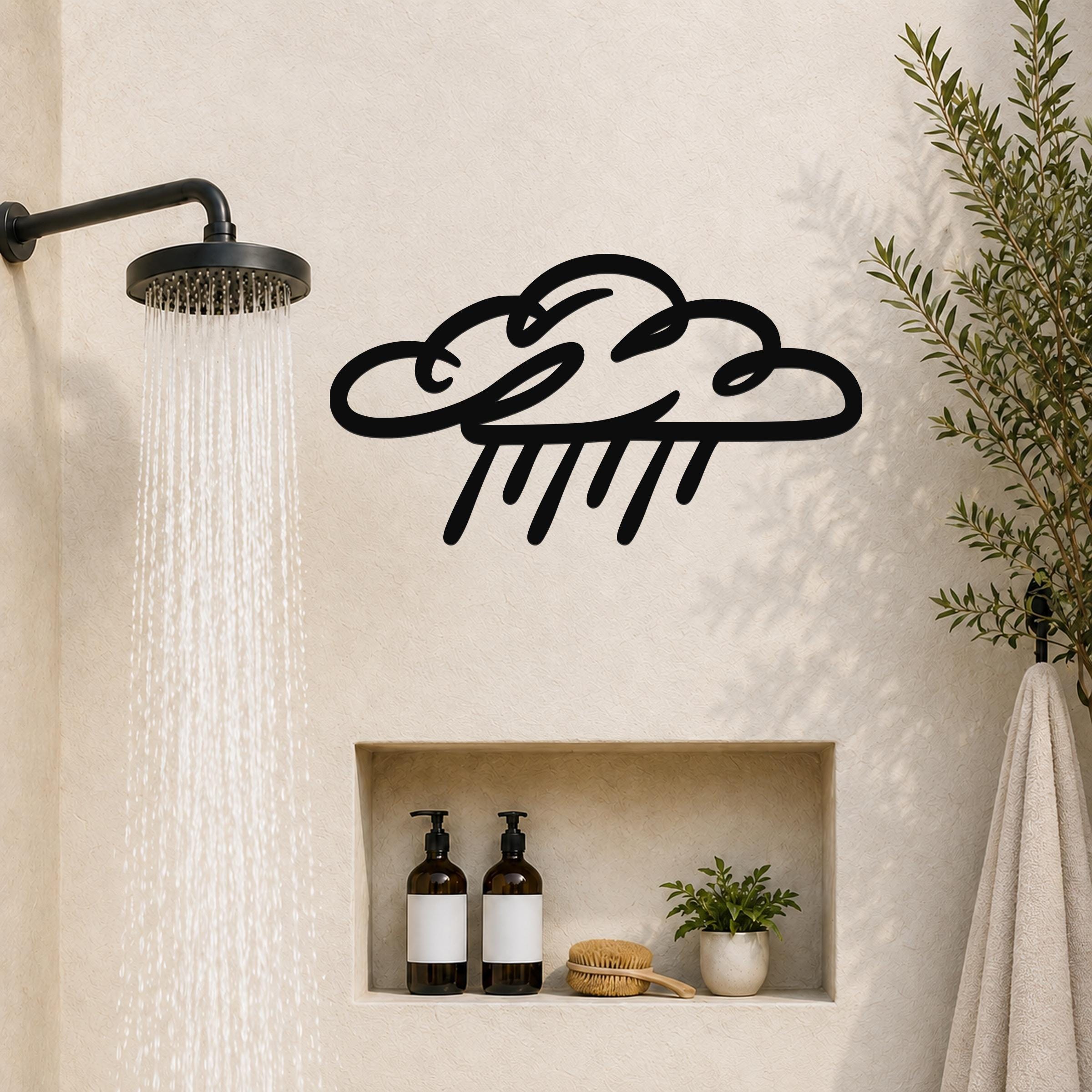 Black metal rain cloud wall art with raindrop cutouts, mounted on a bathroom wall above a built-in shelf.