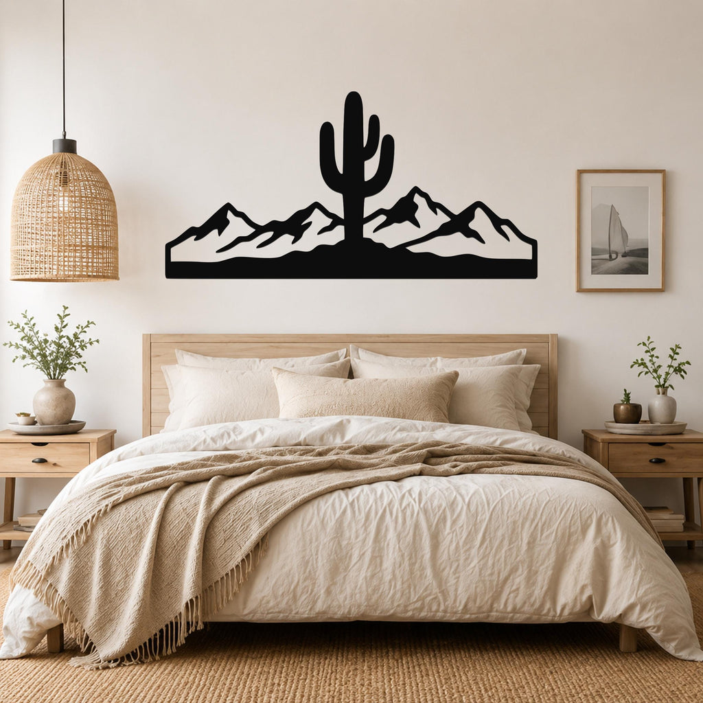Black metal wall art featuring a saguaro cactus and mountain silhouette, mounted above a bed in a neutral bedroom.
