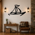 Black metal sailboat wall art with bold silhouette lines, mounted on a shiplap wall above a wooden console table in a living room.