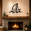 Black metal sailboat wall art with motion-line cutouts, mounted above a stone fireplace in a rustic living room.