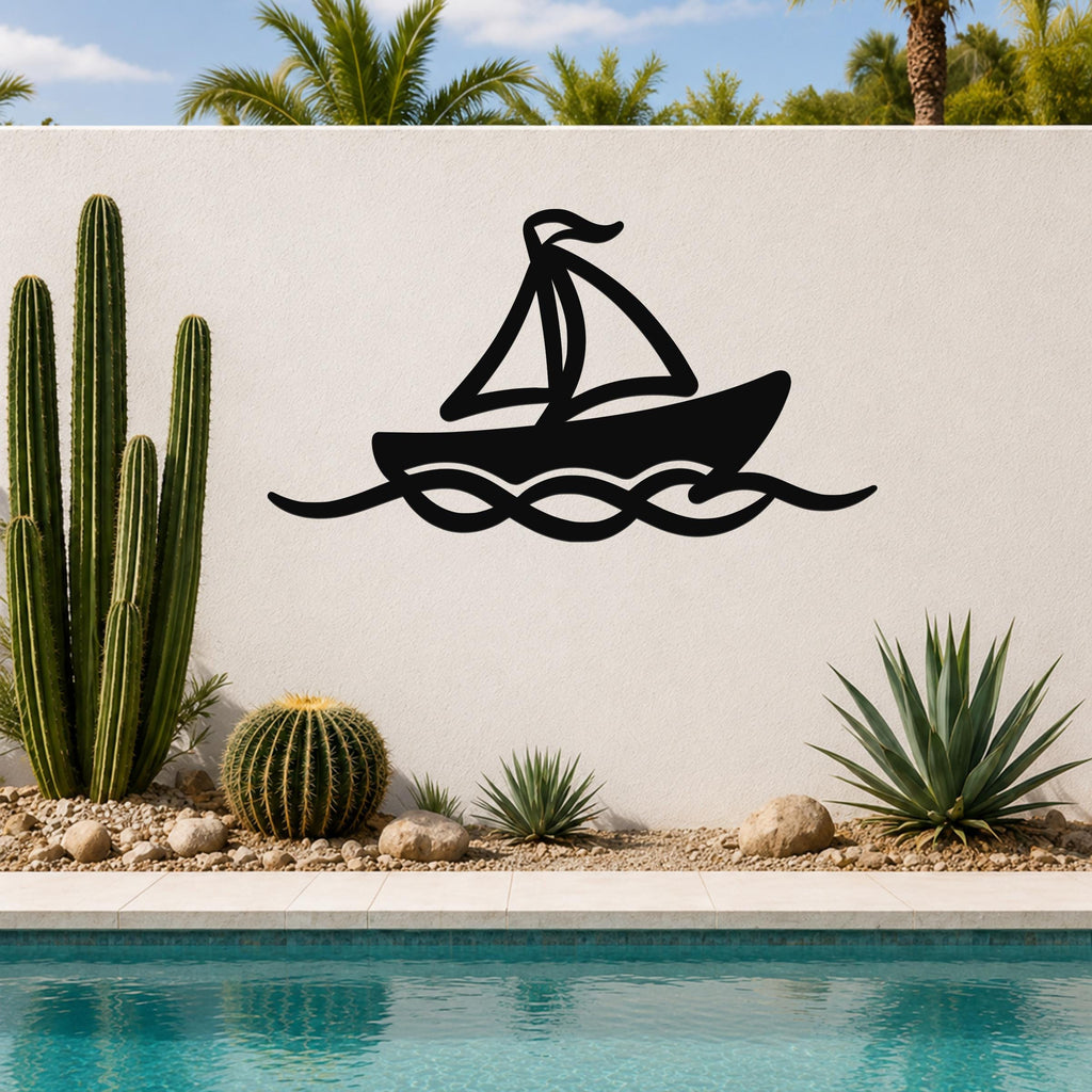 Black metal sailboat wall art with wave cutouts, mounted on a white outdoor wall above a pool with cacti and palm trees in the background.