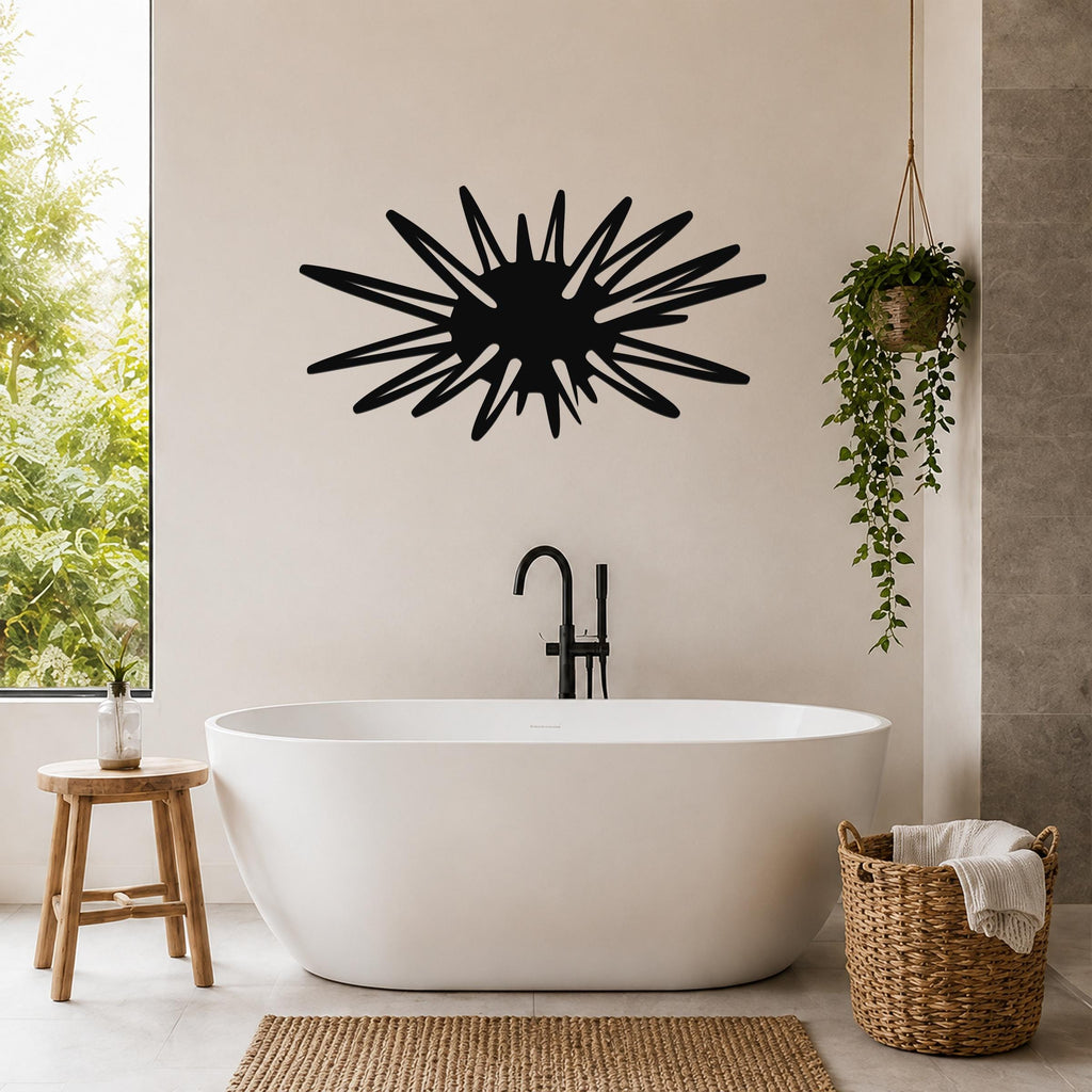Black metal wall art in a sea urchin silhouette with radiating spines, mounted on a bathroom wall above a freestanding tub.