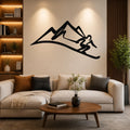 Black metal wall art silhouette of a skier in motion on a mountain slope, mounted above a beige sofa in a living room.