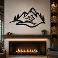 Black metal wall art featuring a skier silhouette and mountain range with pine trees, mounted above a fireplace in a living room.
