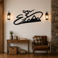 Black metal wall art featuring a skier silhouette and mountain range, mounted on a shiplap wall above a wooden console table in a living room.
