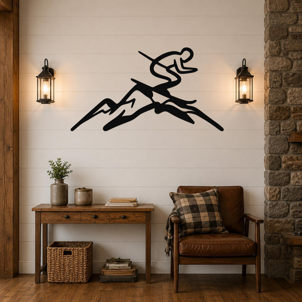 Black metal wall art featuring a skier silhouette in motion above mountain peaks, mounted on a shiplap wall above a wooden console table in a living room.