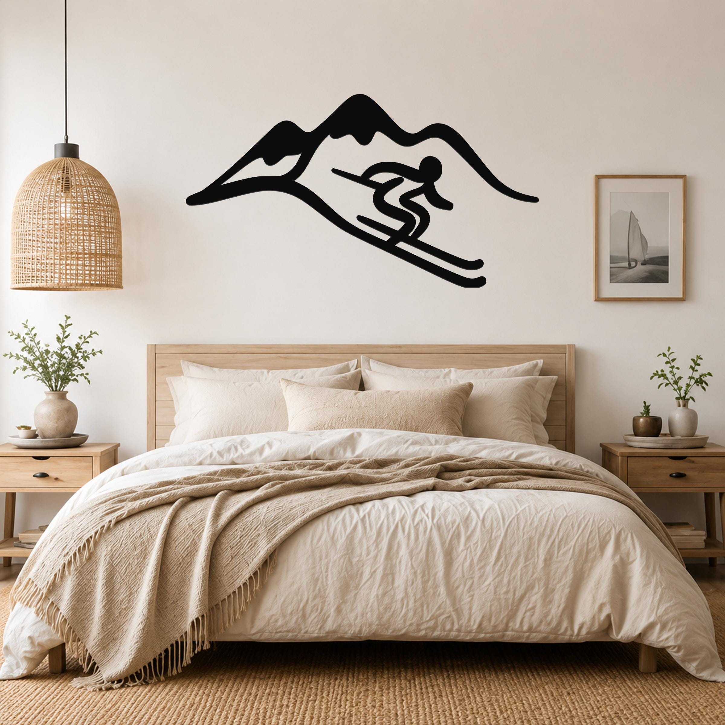 Black metal wall art featuring a skier silhouette in motion against a mountain range, mounted above a wooden bed in a neutral bedroom.
