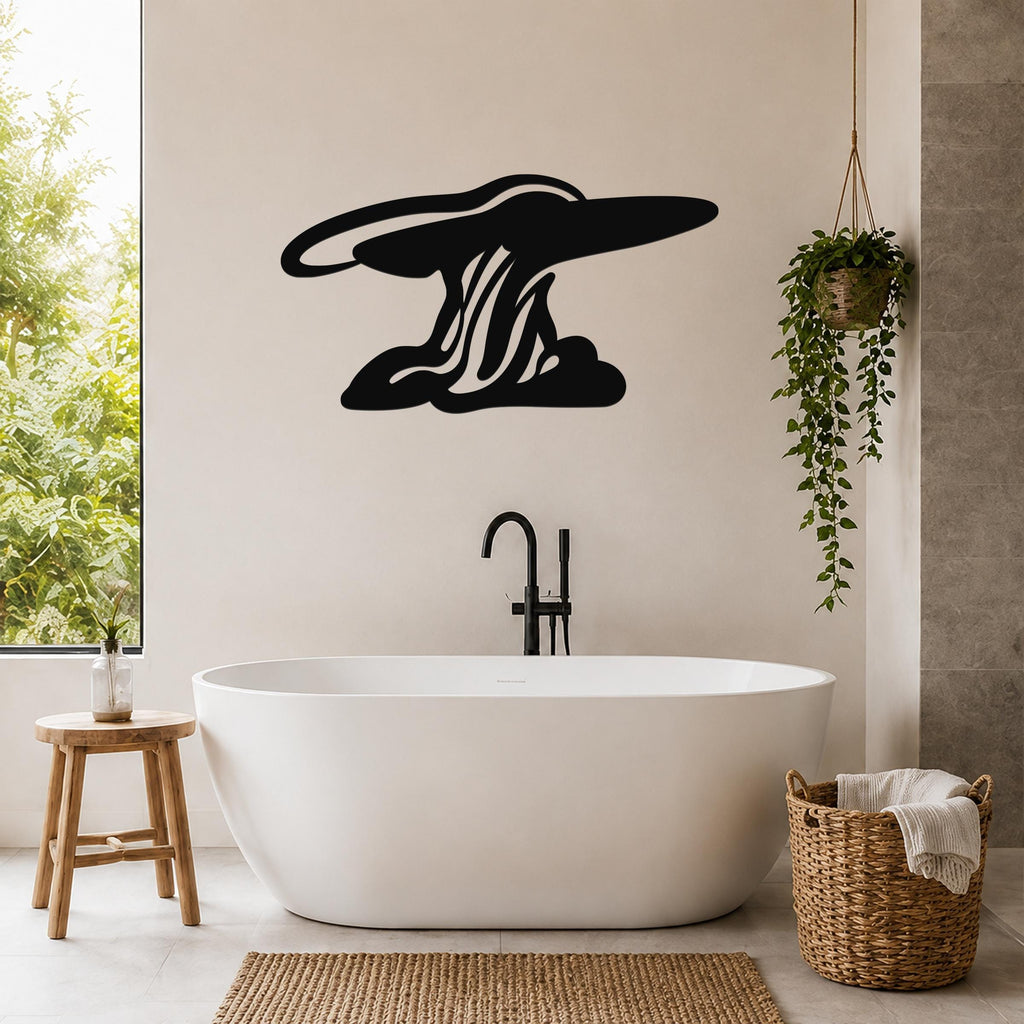 Black metal wall art silhouette of a storm cloud with internal wave-like cutouts, mounted on a bathroom wall above a freestanding tub.