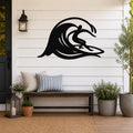 Black metal wall art cutout of a surfer riding a flowing wave, mounted on a white shiplap wall above a wooden bench on a porch.