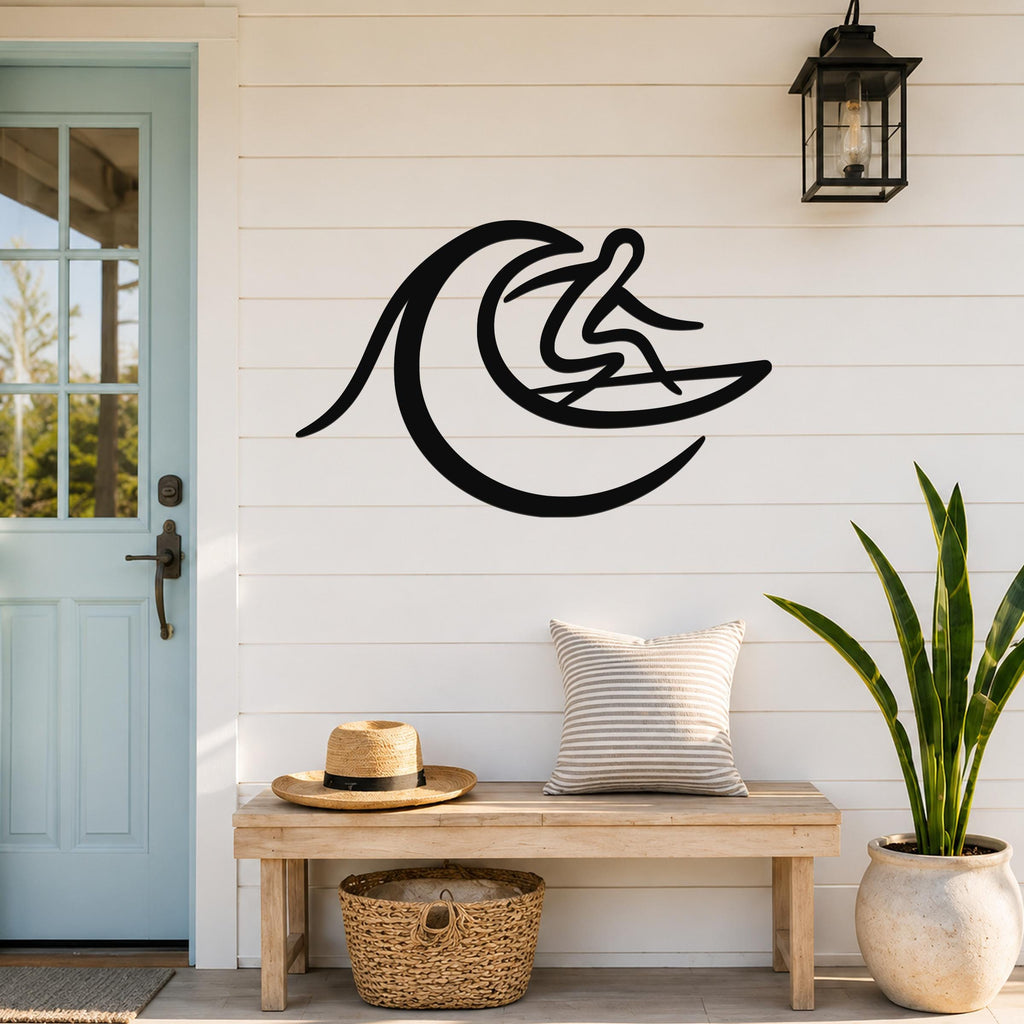 Black metal surfer wall art with a minimalist wave silhouette, mounted on a white shiplap wall above a wooden bench in a porch entryway.