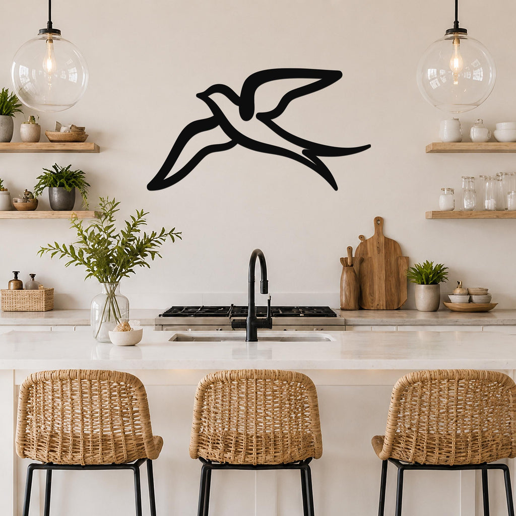 Black metal swallow bird wall art with a graceful silhouette, mounted above a kitchen counter in a bright, modern kitchen.