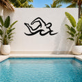 Black metal swimmer wall art with fluid motion cutouts, mounted on a white outdoor wall above a pool, flanked by potted plants.