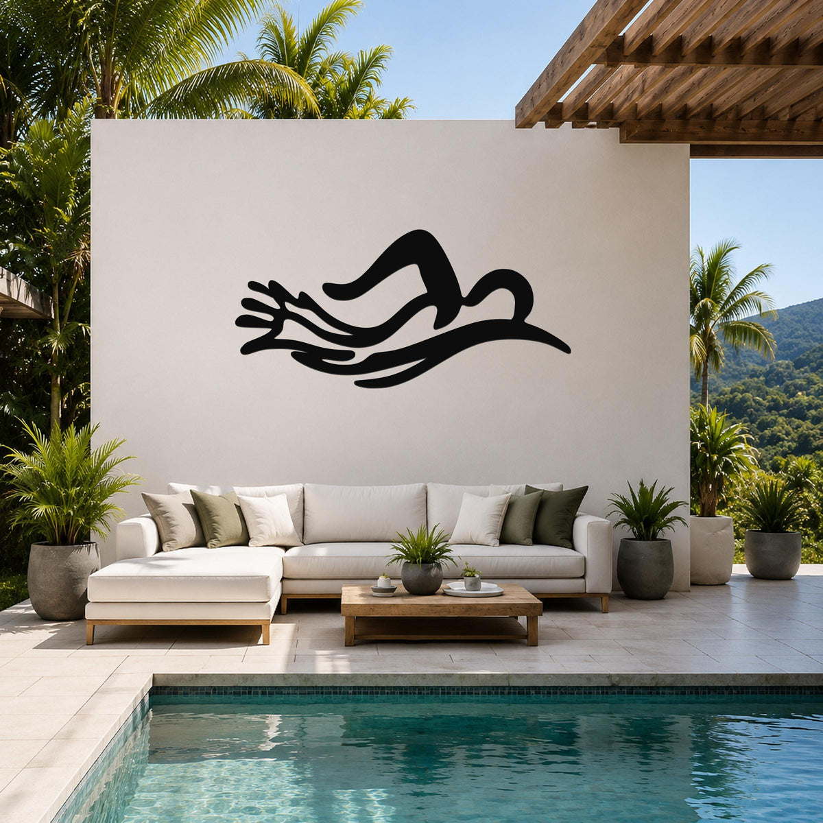 Black metal swimmer wall art with fluid motion cutouts, mounted on a white outdoor wall above a sofa in a patio living area.