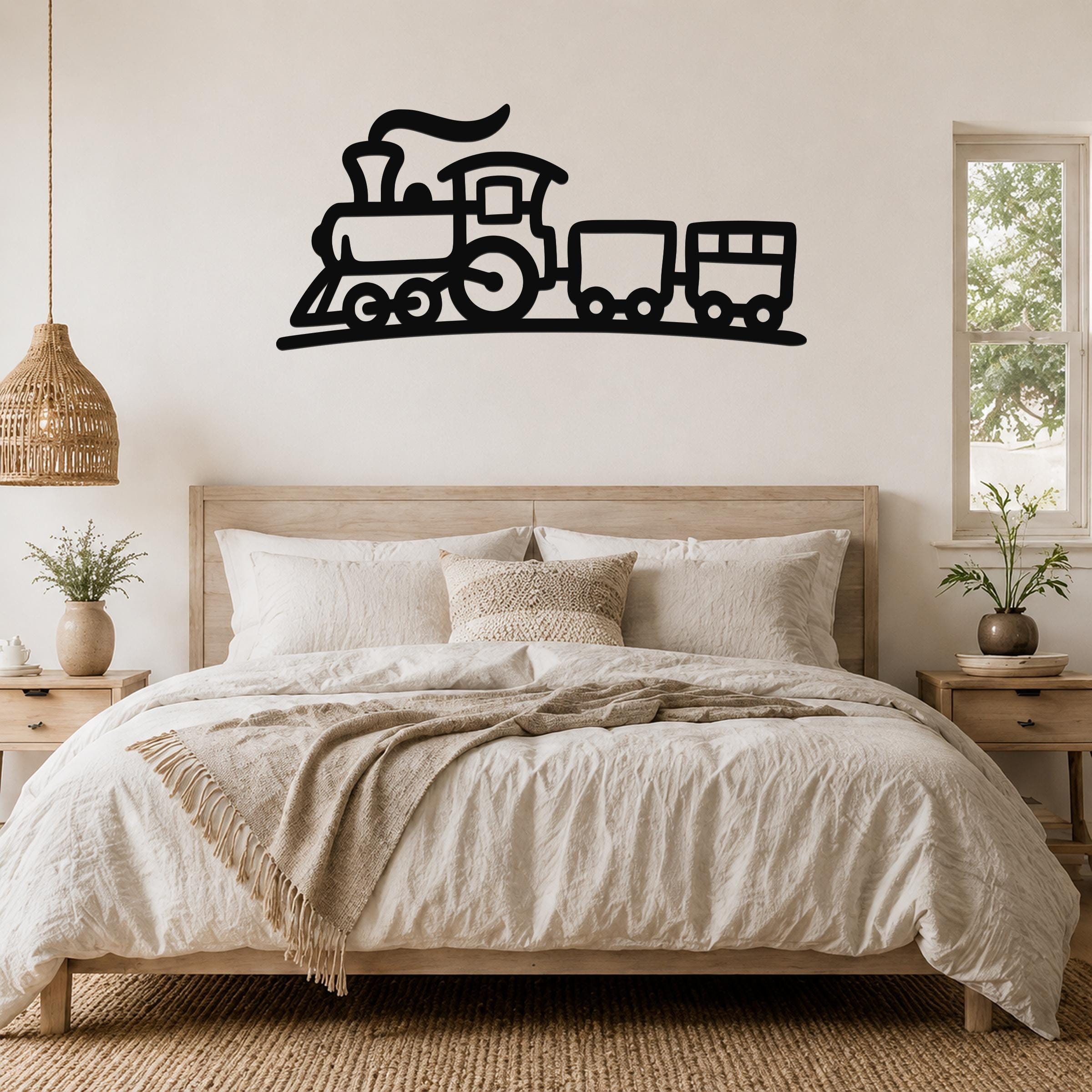 Black metal train wall art with a silhouette design of a locomotive and two cars, mounted above a wooden bed in a neutral bedroom.
