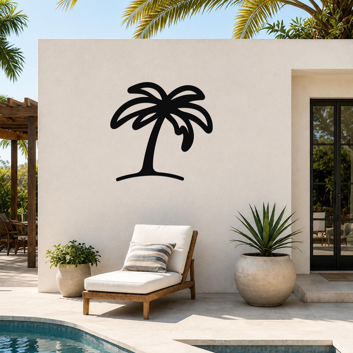 Black metal palm tree wall art with a silhouette design, mounted on an outdoor patio wall above a lounge chair near a pool.