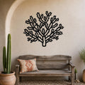 Black metal Cholla cactus wall art with intricate branch cutouts, mounted on a textured beige wall above a rustic wooden bench in a desert-themed entryway.