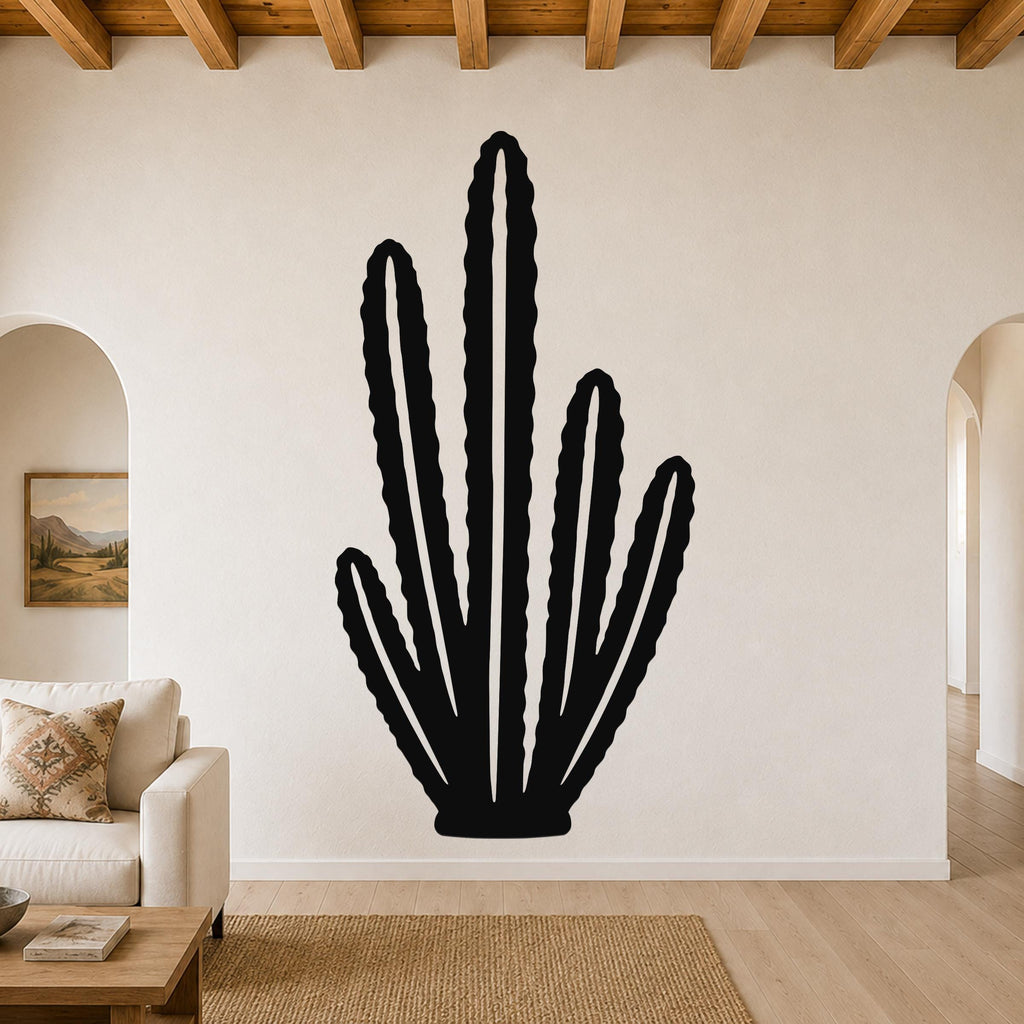 Black metal wall art cutout of an organ pipe cactus with multiple vertical arms, mounted on a living room wall above a sofa.