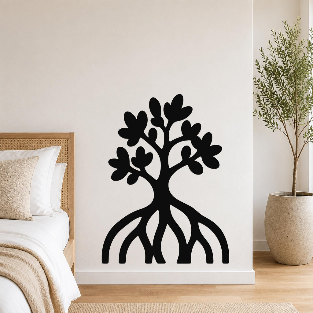Black metal wall art in a tree silhouette with visible root and leaf cutouts, mounted on a white wall above a bed in a bedroom.