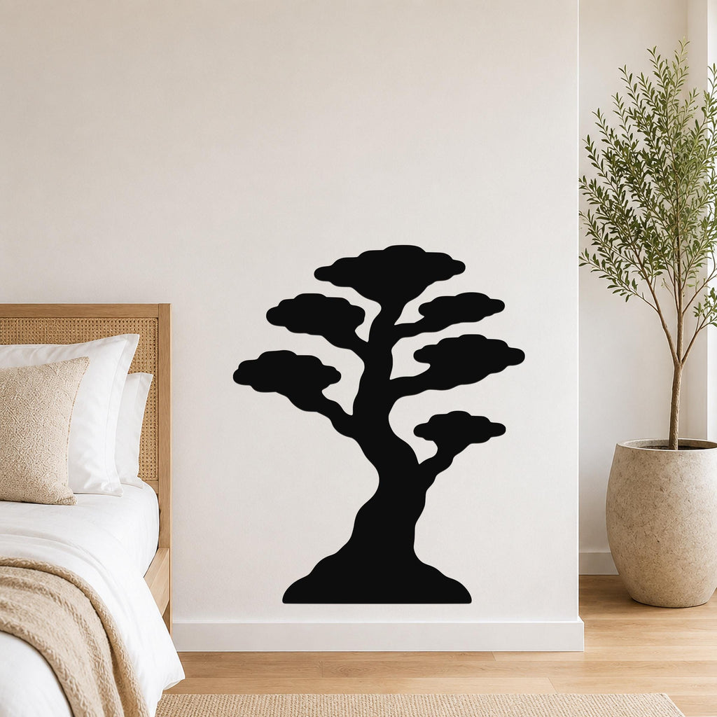 Black metal bonsai tree wall art with layered canopy cutouts, mounted on a white bedroom wall above a bed.