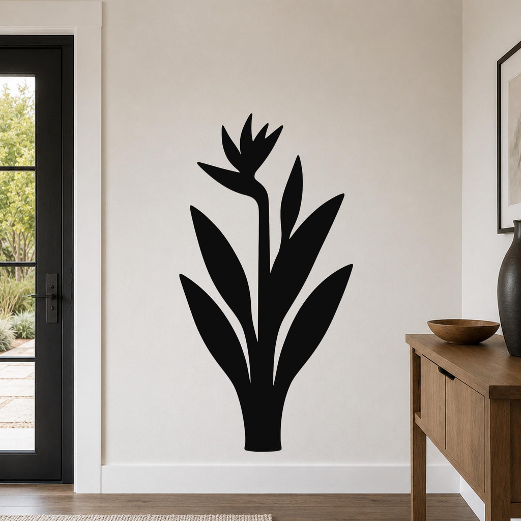 Black metal Bird of Paradise wall art silhouette with flower and leaf cutouts, mounted on a light-colored wall in a modern entryway.